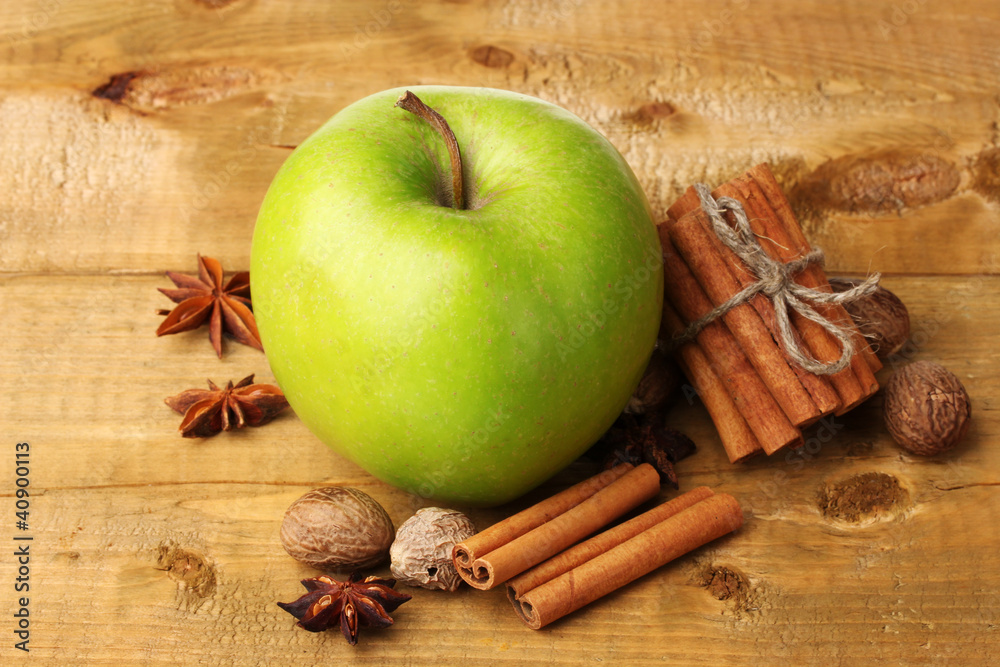 Cinnamon sticks, green apple, nutmeg,and anise on wooden table Cinnamon sticks, green apple, nutmeg,and anise on wooden table