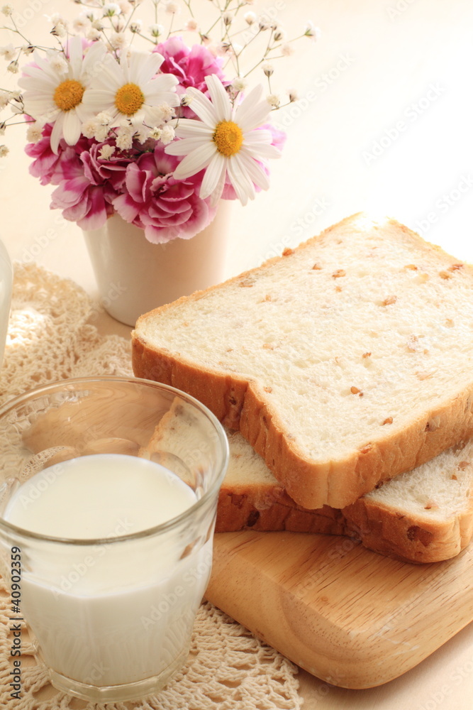 Milk and wheat bread with flower on background Milk and wheat bread with flower on background