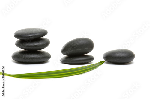 arrangement Balanced black zen pebbles with green leaf