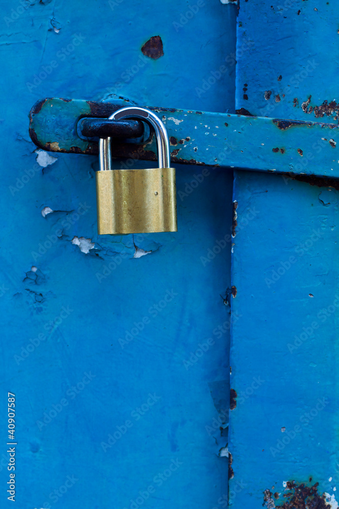 Blue locked door with gold padlock Blue locked door with gold padlock