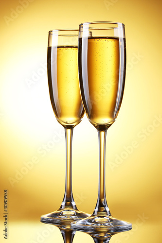 glasses of champagne on yellow background