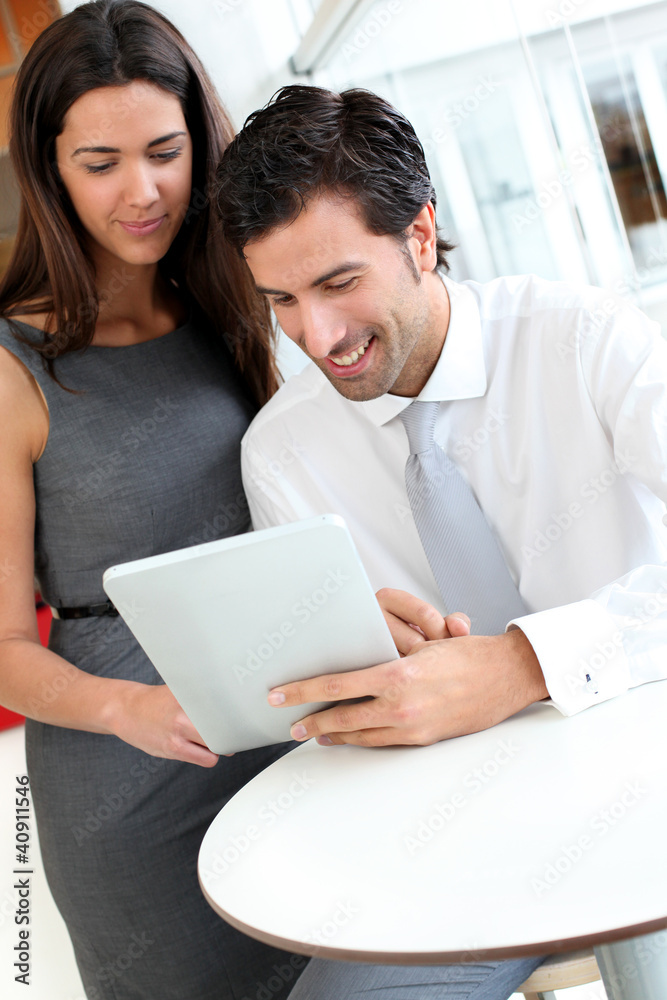 Business people websurfing on tablet during breaktime
