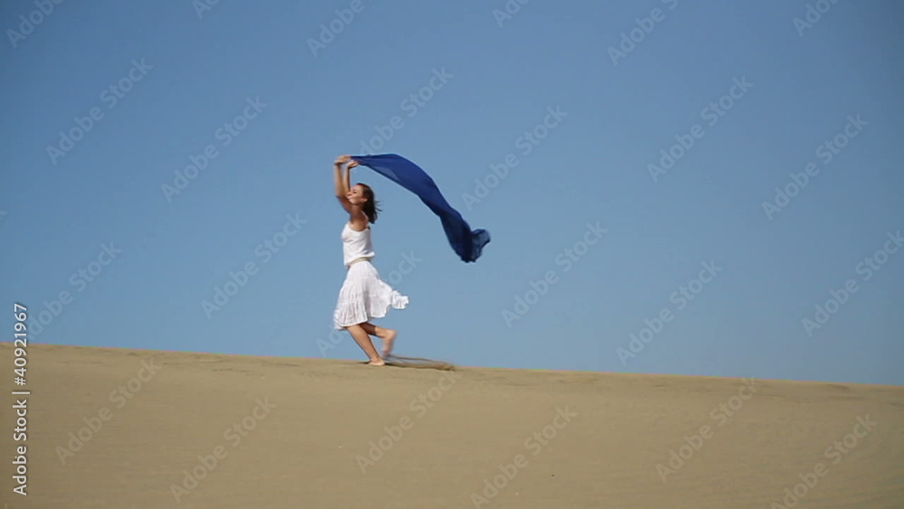 Woman with waving sarong running in the desert, slow motion Woman with waving sarong running in the desert, slow motion