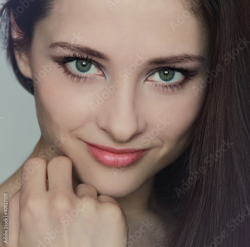 Closeup portrait of sexy young beautiful woman with hand near th