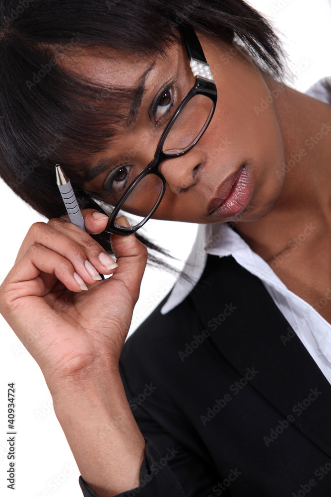 Businesswoman with pen lifting glasses frame