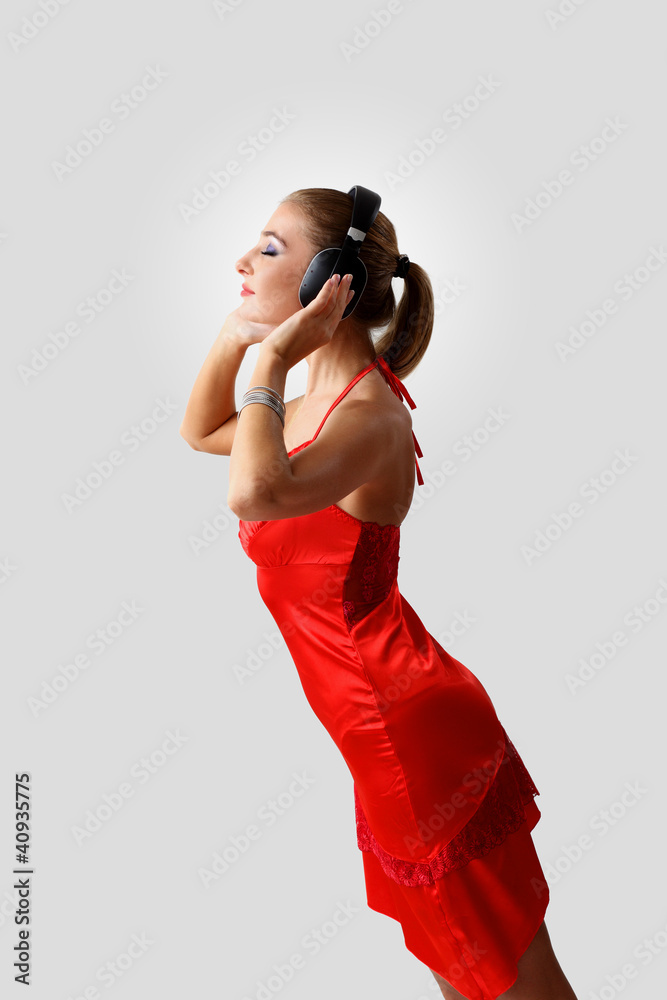Obraz premium Young woman in evening dress with headphones
