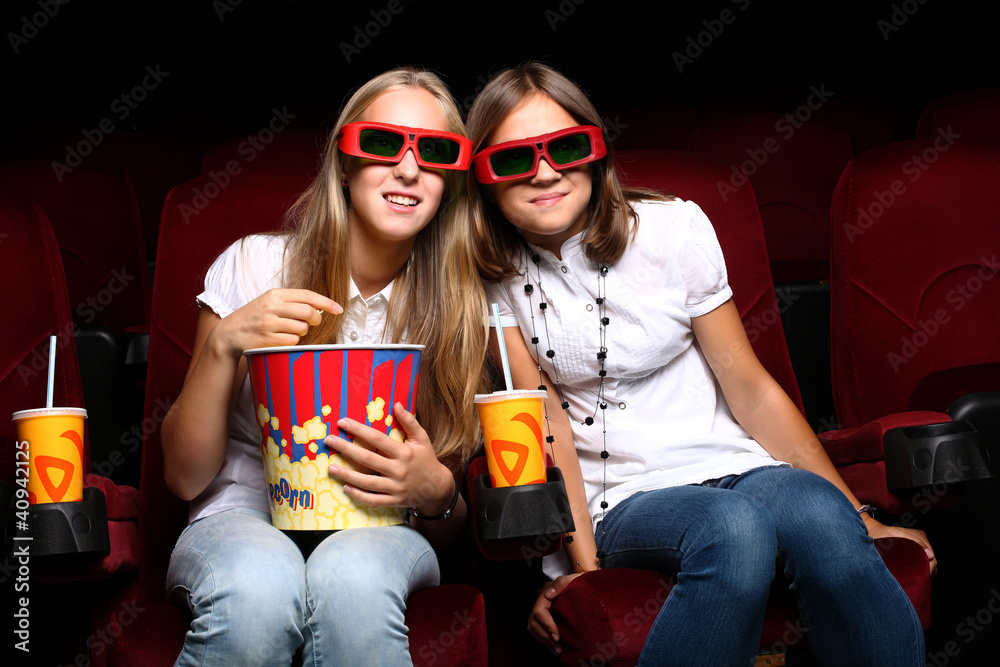 Fototapeta premium Two young girls watching in cinema