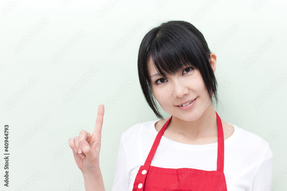 指差すエプロン姿の女性