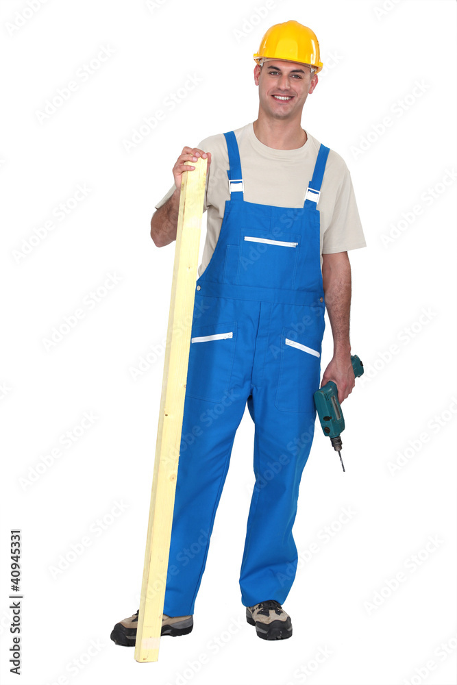 Builder with a drill and timber Builder with a drill and timber
