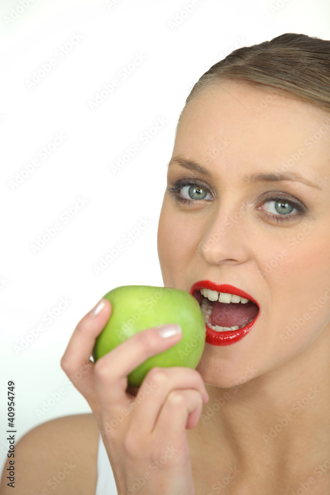 Woman biting into green apple