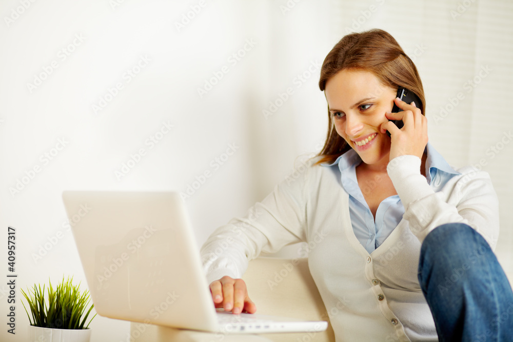 Woman working on laptop and on the phone Woman working on laptop and on the phone
