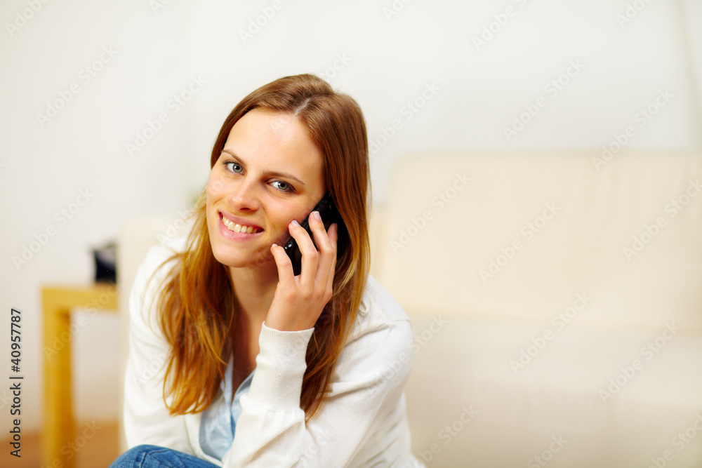 Friendly girl speaking on the phone at home Friendly girl speaking on the phone at home