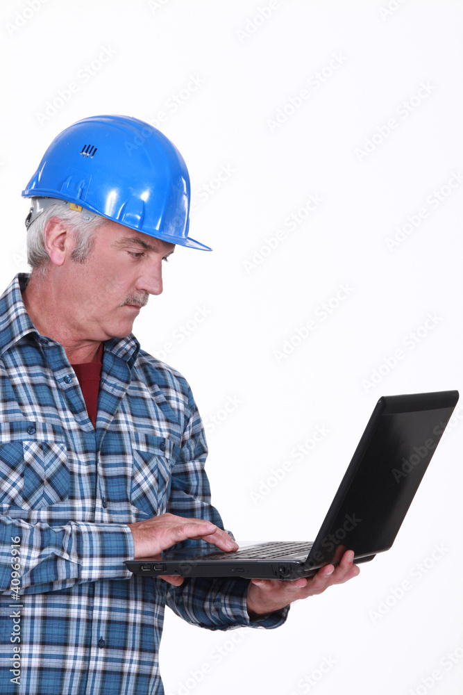 mature craftsman working on his laptop