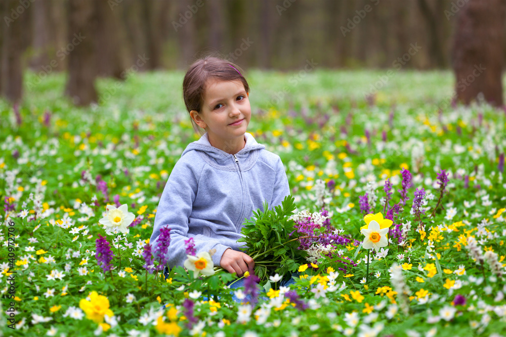 Cute little girl picking flowers in the spring forest Cute little girl picking flowers in the spring forest