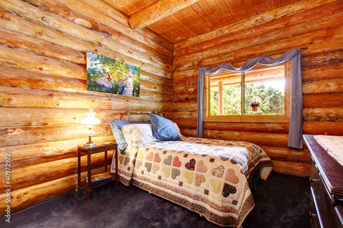 Log cabin rustic bedroom with blue curtains. © Iriana Shiyan