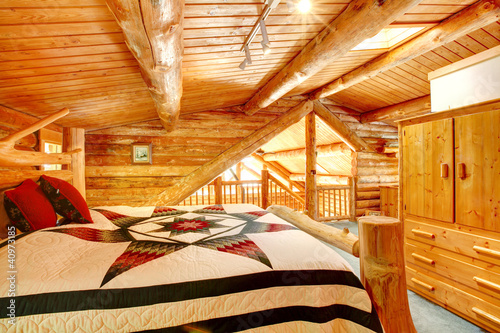Log cabin bedroom under wood large ceiling.
