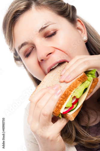 Beautiful happy woman eating sandwich