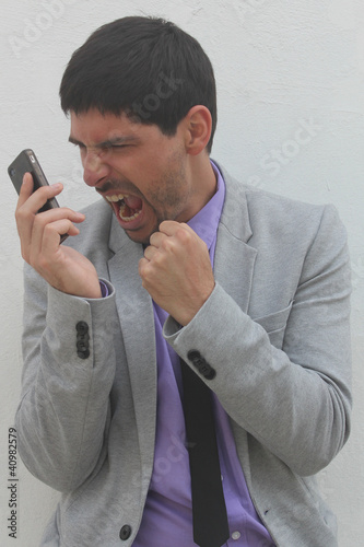 Foto An angry businessman is shouting at his mobile phone