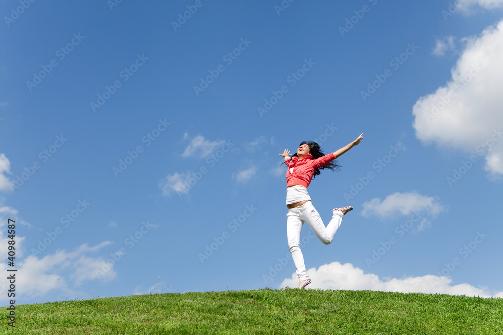 pretty young woman jumping on green grass pretty young woman jumping on green grass