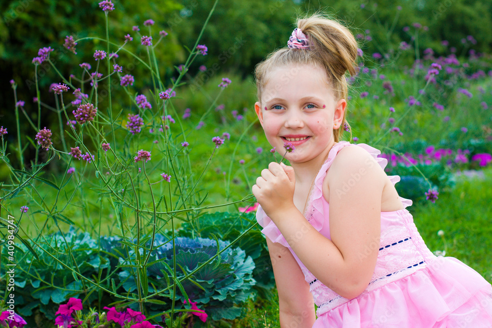 The beautiful girl smells flowers in green grass The beautiful girl smells flowers in green grass