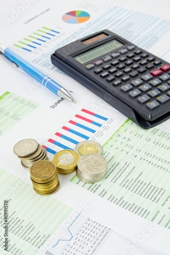 Calculator, pen, coins on a colorful business background