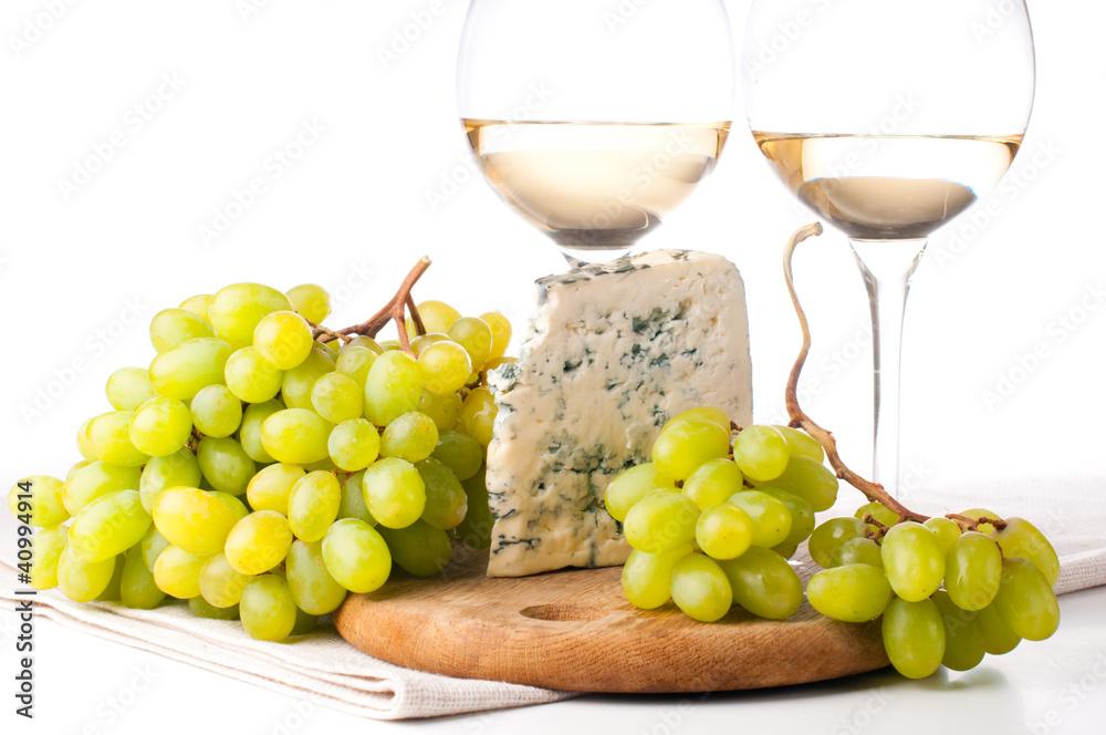 Two glasses of white wine, blue cheese and a grapes