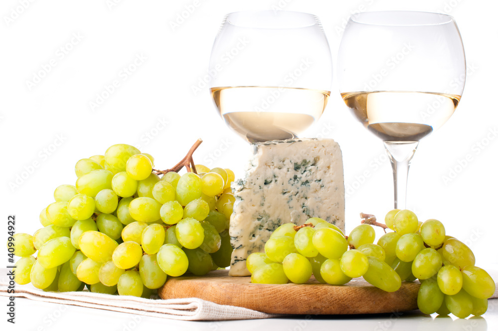 Two glasses of white wine, blue cheese and a grapes