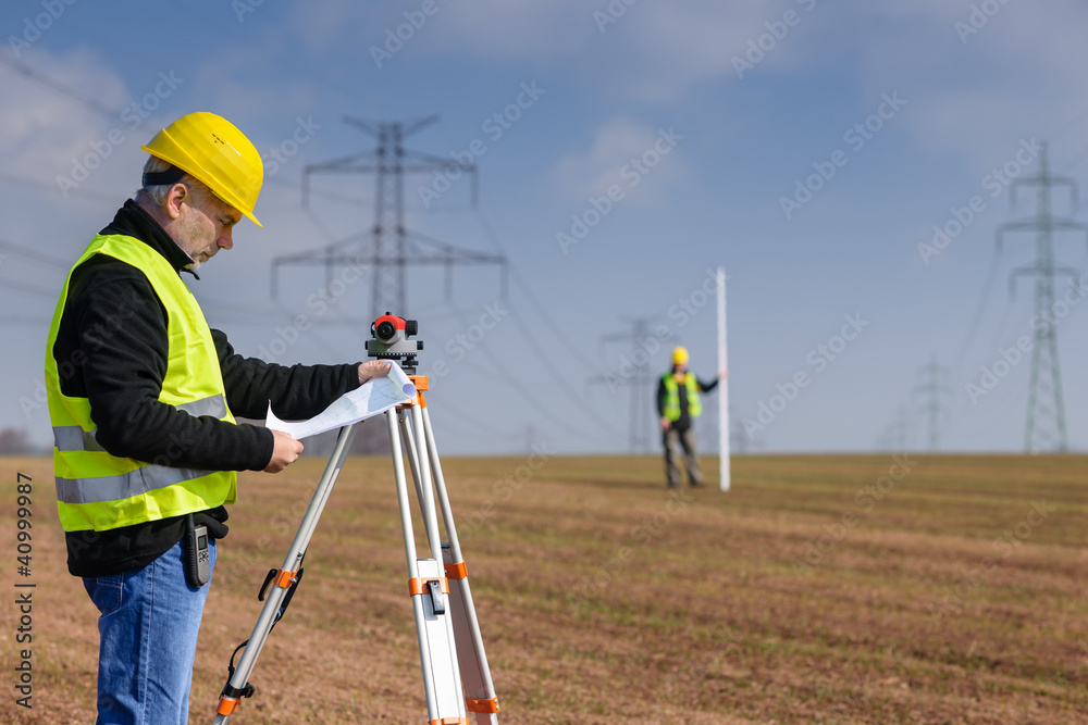 Geodesist measure land on construction site Geodesist measure land on construction site