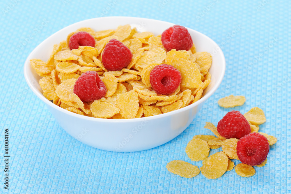 Cornflakes in white bowl with raspberry