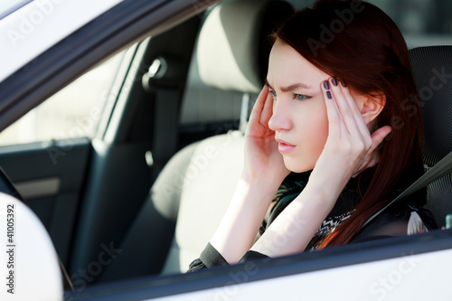 Woman with headache in a car