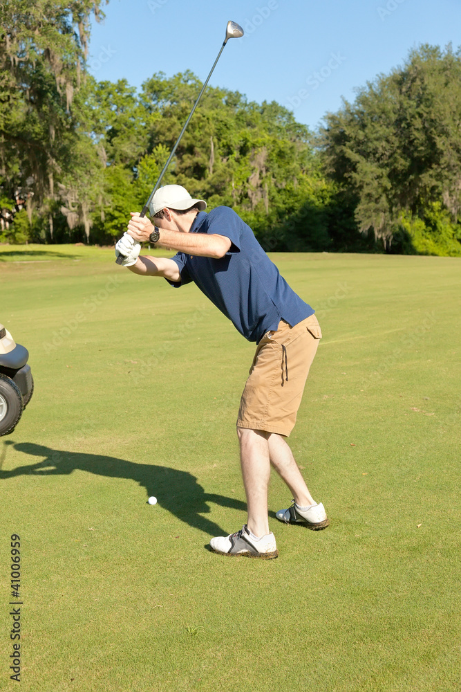 Obraz premium Young Male Golfer Preparing to Hit the Golf Ball
