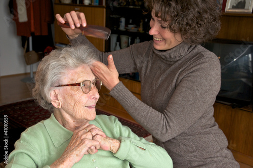 Ältere Dame mit Betreuerin beim Frisieren