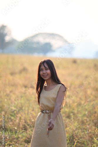 face of women standing in the grass field with evening light