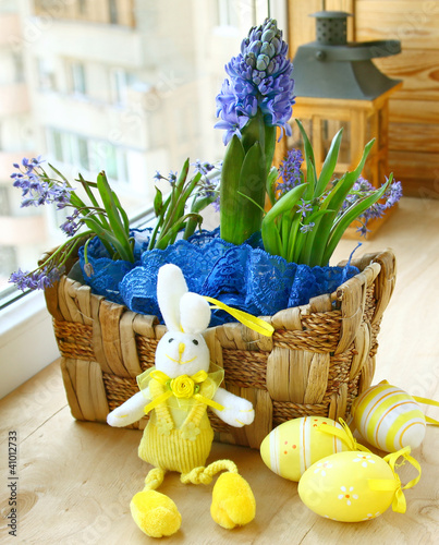 Spring flowers in a small basket and easter rabbit photo