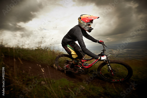 Young man riding a mountain bike downhill style