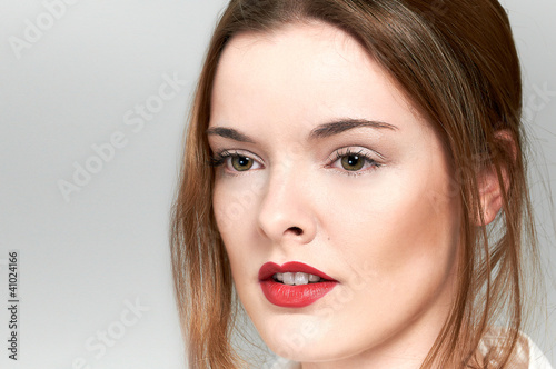 Fashion shot of beautiful woman face portrait, red lips, green e