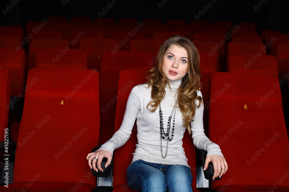 Young girl in cinema watching movie