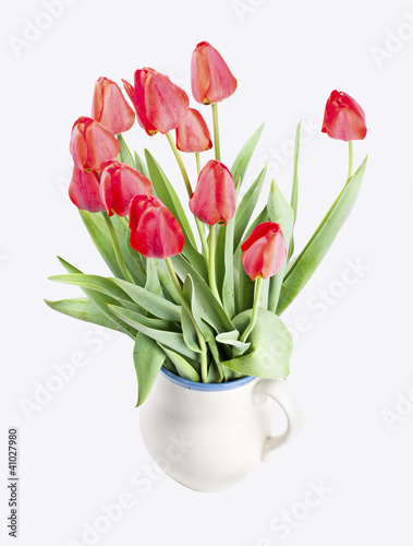 Bouquet of red tulips in an old jar isolated on white background