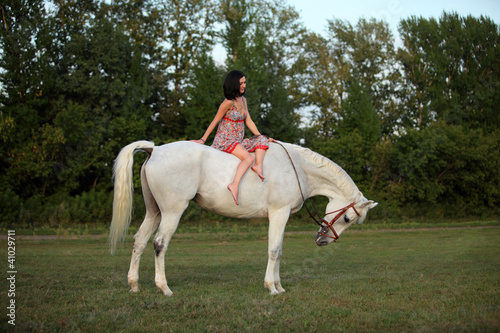 Pretty young girl together with her horse