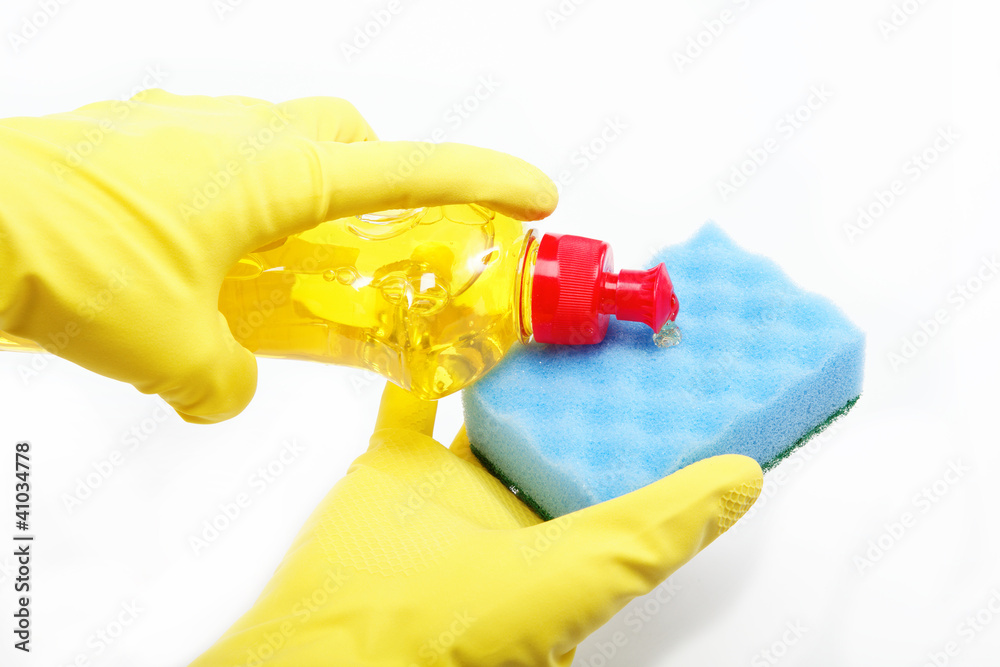 Hands in rubber gloves with a bottle of detergent and sponge on Hands in rubber gloves with a bottle of detergent and sponge on
