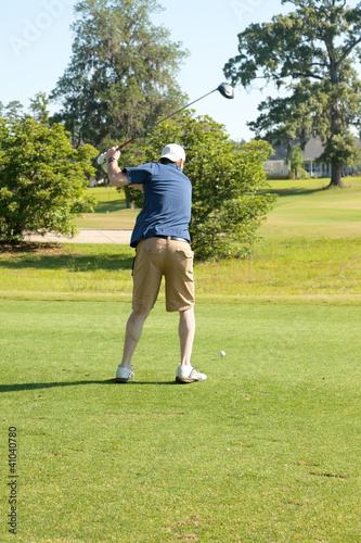 Male golfer teeing off with driver