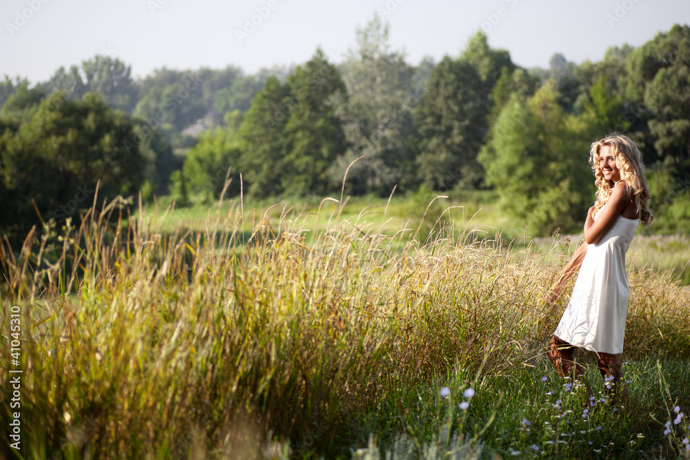 Beautiful girl walking on the meadow in summer day Beautiful girl walking on the meadow in summer day