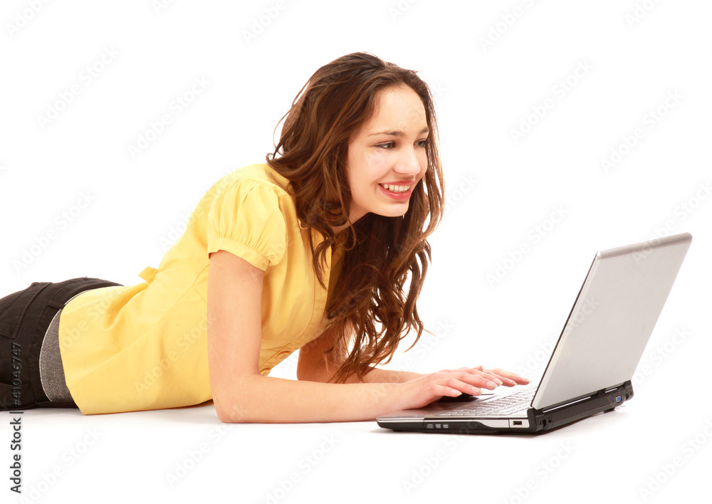Portrait of beautiful young woman lying on floor with a laptop Portrait of beautiful young woman lying on floor with a laptop