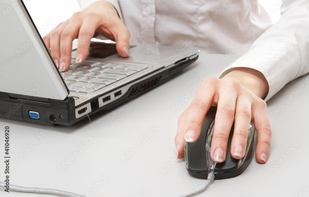 A young businesswoman working on a laptop, focus on her hands A young businesswoman working on a laptop, focus on her hands