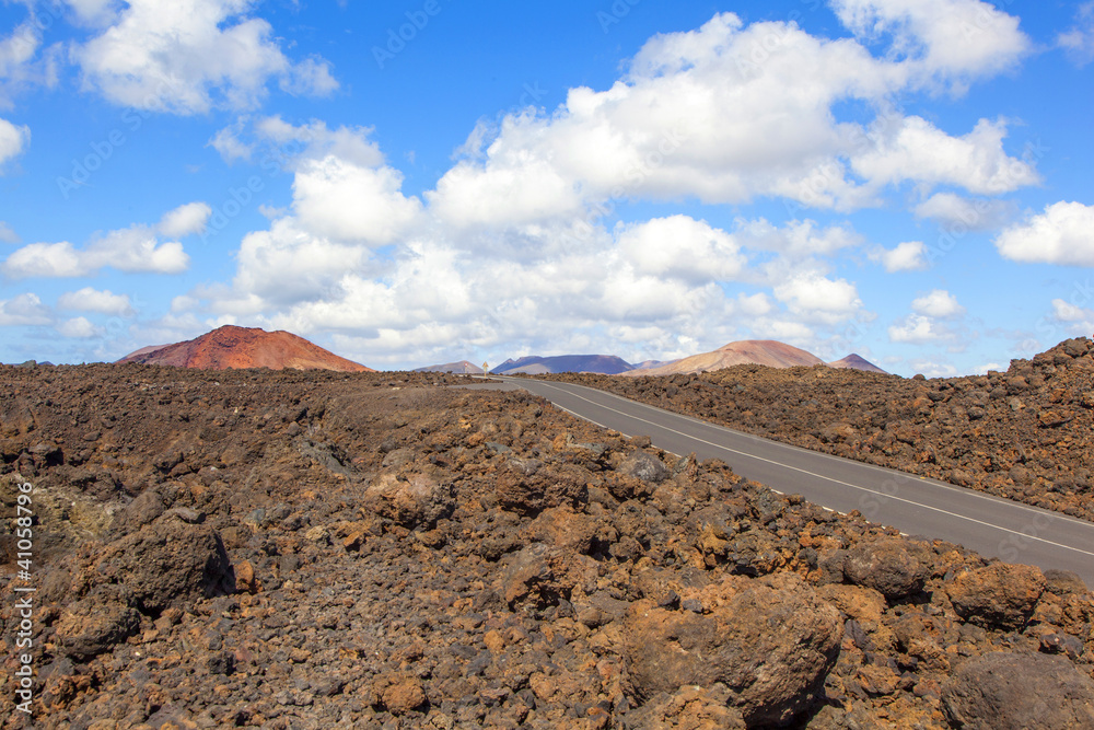 Road through lava rocks and volcanic mountains. Los Hervideros.
