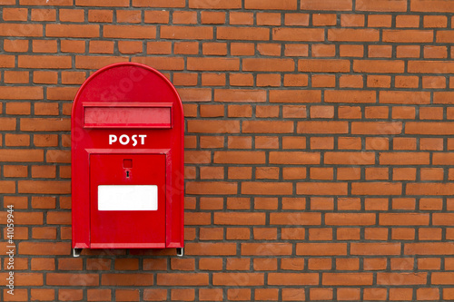 red mailbox on stone wall