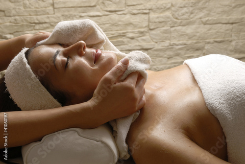 Joven mujer recibiendo tratamiento facial en un spa.