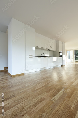 Beautiful new apartment, interior, kitchen. The space is large and bright, The kitchen is white and new, there is nothing on the floor but the parquet is clean and new.