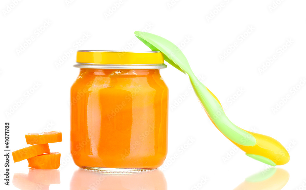 Jar of baby puree with carrot and spoon isolated on white Jar of baby puree with carrot and spoon isolated on white