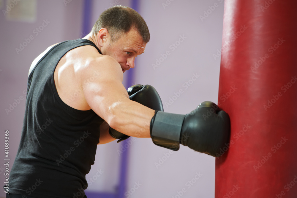 boxer man at boxing training with heavy bag